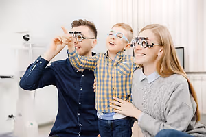 A young boy is wearing glasses and has his parents by his side.