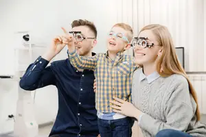 A young boy is wearing glasses and has his parents by his side.