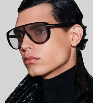 A model wearing a black turtleneck and sunglasses