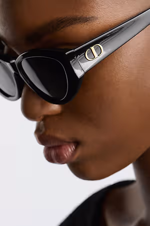Black Dior sunglasses with gold logo on a woman's face