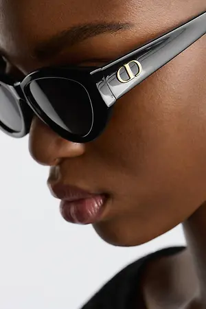 Black Dior sunglasses with gold logo on a woman's face