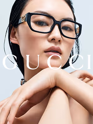 Close-up portrait of a woman wearing black Gucci eyeglasses with gold accents
