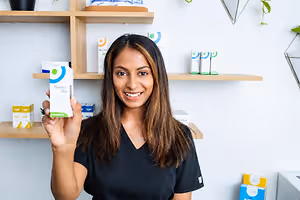 Optometry professional holding a box of Thealoz Duo eye drops