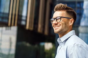 Business man adjusting glasses and smiling