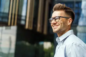Business man adjusting glasses and smiling