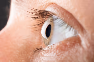 A close-up view of a human eye with long eyelashes and a slightly blurry view of the eye itself