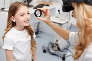 Girl getting eye checked by a doctor in a medical room