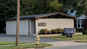 An optician's clinic with a yellow fire hydrant in front and a sign reading 'Optometric Eye Clinic'.