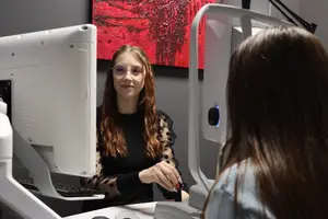 female optician performing eye exam on young female patient