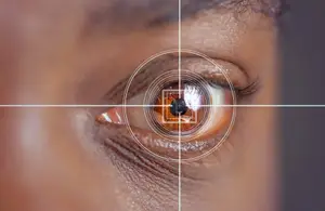 A close up of a woman's eye with a black dot in the center of the iris and a white line on the side