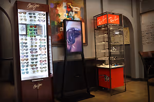 Two shelves displaying branded sunglasses store interior