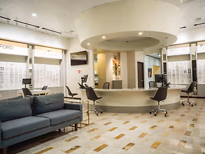 A boutique style optical shop with a reception desk and a large couch in the foreground
