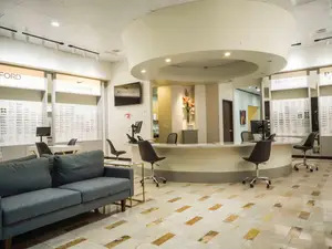 A boutique style optical shop with a reception desk and a large couch in the foreground
