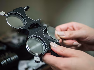 Closeup of an optometrist's hand holding an optical instrument with lenses