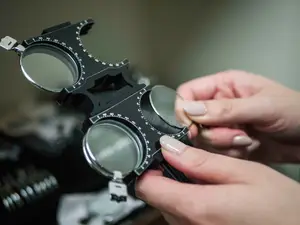 Closeup of an optometrist's hand holding an optical instrument with lenses