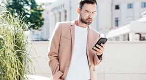 Businessman standing outside on a balcony using a cell phone
