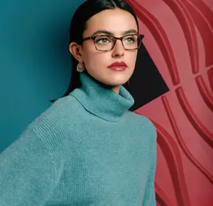 woman wearing glasses and a teal turtleneck