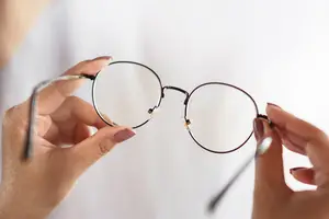 Close up of hands holding up eyeglasses