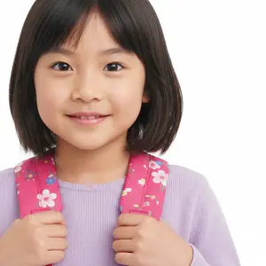 A young girl with short black hair wearing a pink floral backpack and a purple sweater.