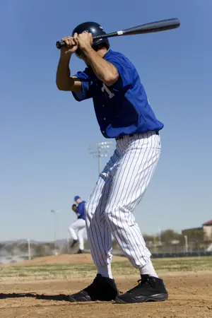 Baseball player in blue and white uniform with the number 1 on his jersey swings a black bat