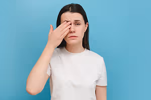 Young woman looking tired rubbing her eyes with her hand