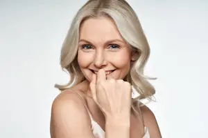 An older woman with blonde hair smiling for a photo