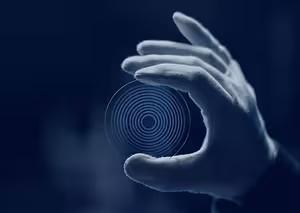 Hand holding a circular object with a spiral pattern