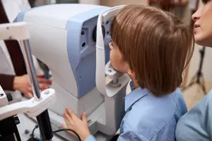A young girl is getting an eye exam with an optometrist in an eye clinic