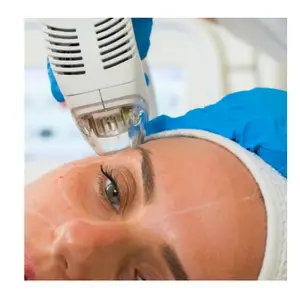 A woman is getting a facial treatment with a device