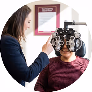 Optometrist adjusting phoropter during eye exam
