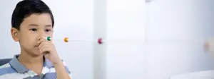 Young boy blowing into a medical device