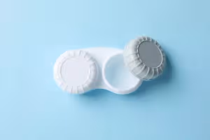 Two contact lenses in a container on a blue background