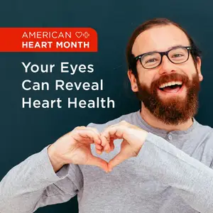 American Heart Month: Your Eyes Can Reveal Heart Health, a smiling man with glasses makes a heart shape with his hands.