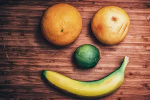 An image of a smiley face made from fruits like oranges and a banana