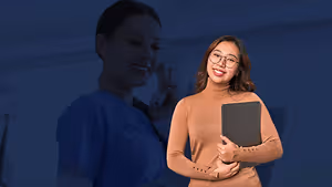 A smiling woman in glasses holds a tablet while another woman in a blue shirt speaks on a phone in a clinic.