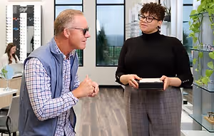 A man and a woman are standing and talking in an optical shop