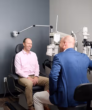 Two men having a conversation in an optometrist's office
