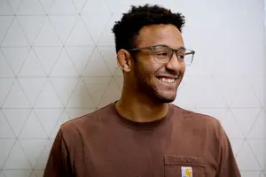 A man wearing glasses is smiling and seems to be posing for a photo