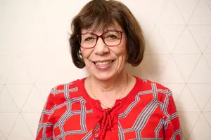 Portrait of a woman in a red dress smiling at the camera