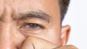 Closeup of a man with his finger in his nose