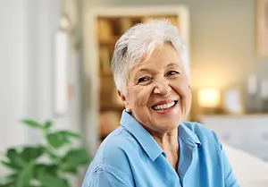 Older woman smiling while sitting on a couch
