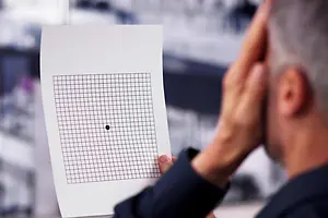 Eye care professional holding an Amsler grid for a patient's vision test