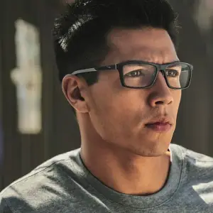 Man wearing glasses looking to the left with a serious expression