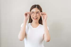 Woman smiling and adjusting her glasses