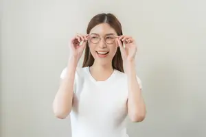Woman smiling and adjusting her glasses