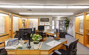 The interior of an optometrist's office, featuring a modern and well-equipped setting with various equipment and display cases for eyewear.