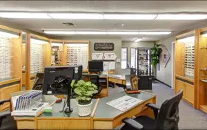 The interior of an optometrist's office, featuring a modern and well-equipped setting with various equipment and display cases for eyewear.