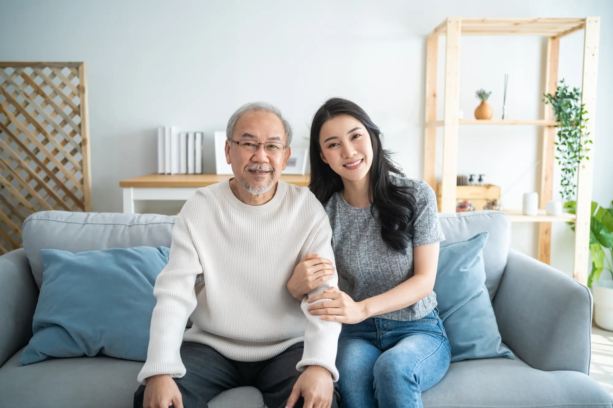 Image of an older man and woman sitting on a sofa in a living room.
