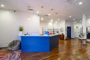 Interior of a beauty salon with a reception desk, wooden floors, and decorative elements