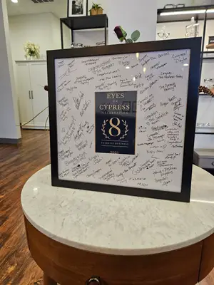 A framed plaque with signatures on it and a number eight is placed on a round table in a room